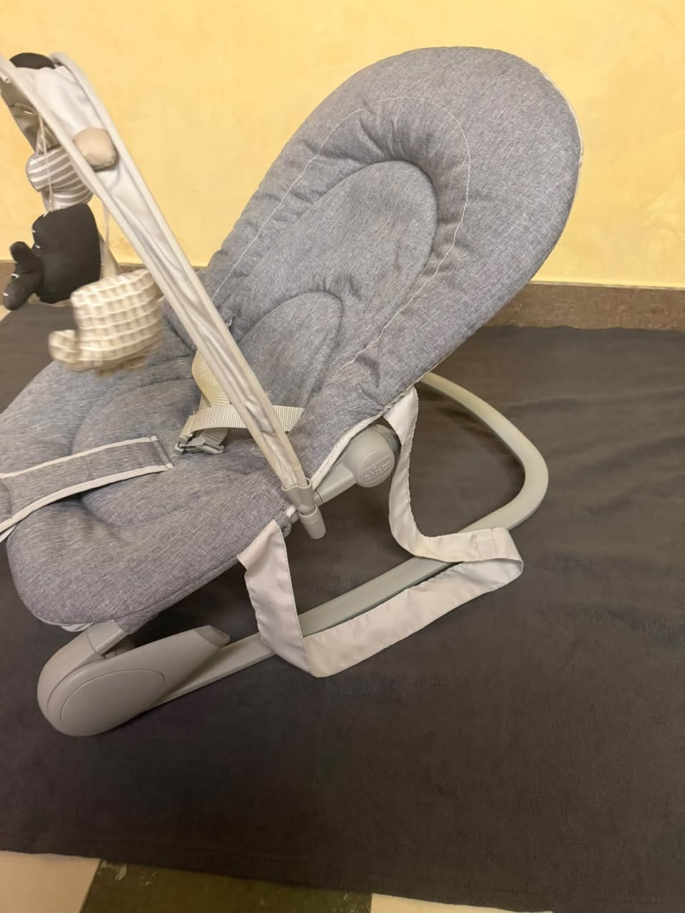Gri bebek sallanır koltuk oyuncaklarla
