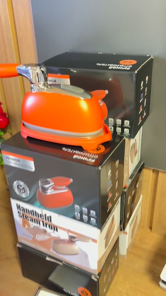 Orange handheld steam iron