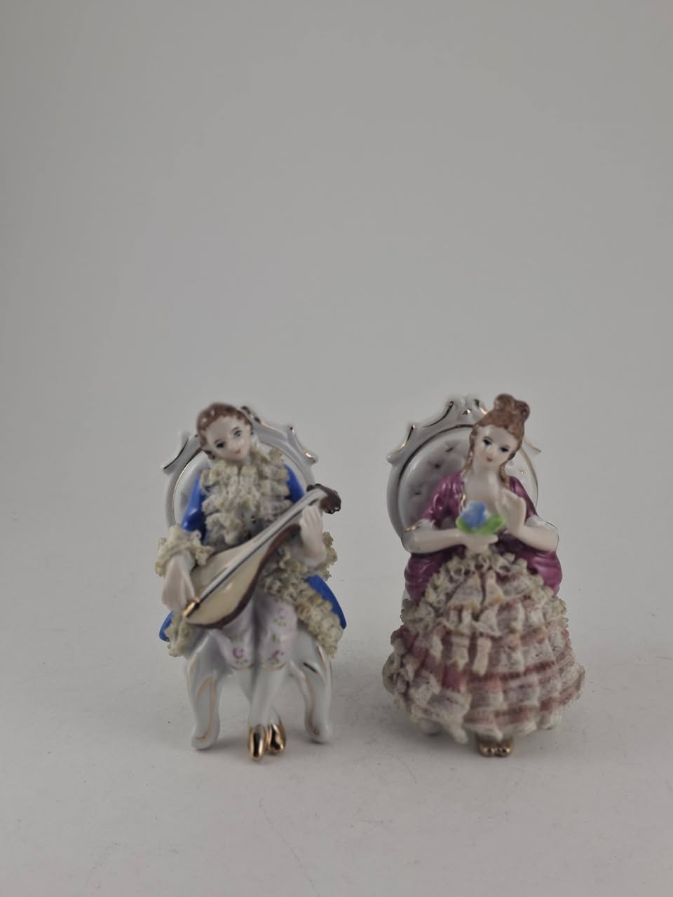Porcelain figurines, musician and lady